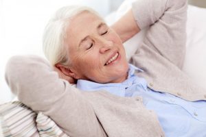 happy senior woman resting on sofa at home