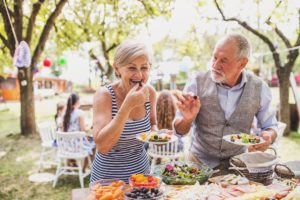 Man and woman plating food at an outdoor event