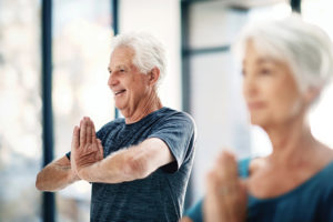 Man and woman performing yoga and pressing their palms together