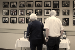 Senior residents looking at Veterans Wall of Honour in their senior residence.